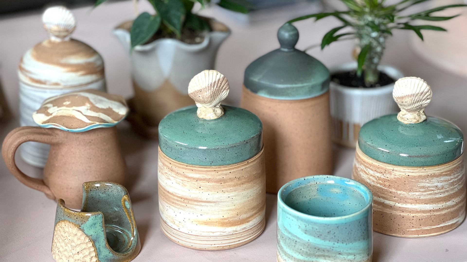 Handmade pottery with blue and green glaze and seashells.